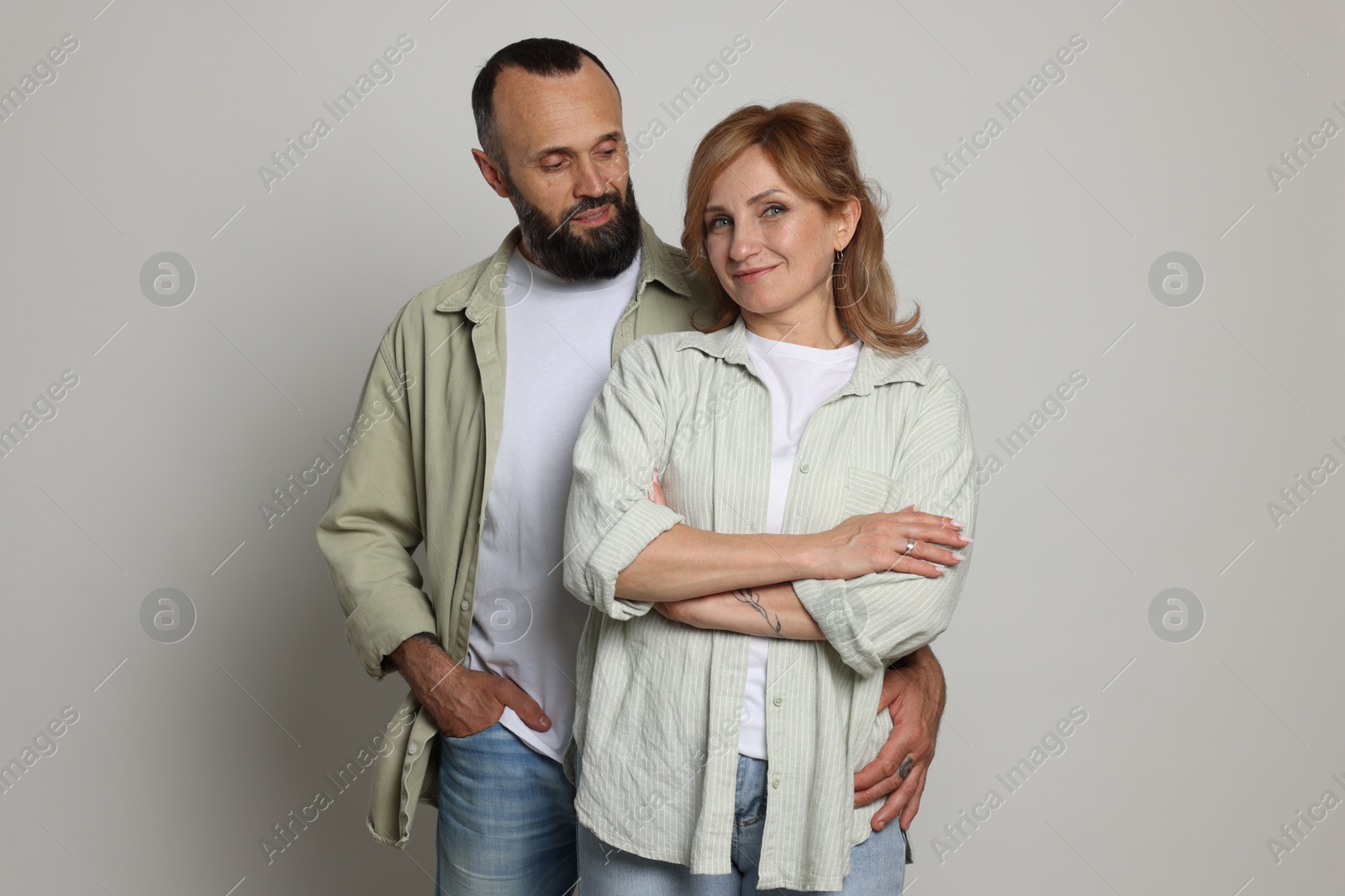 Portrait of lovely couple on light grey background Photo of Portrait of lovely couple on light grey background