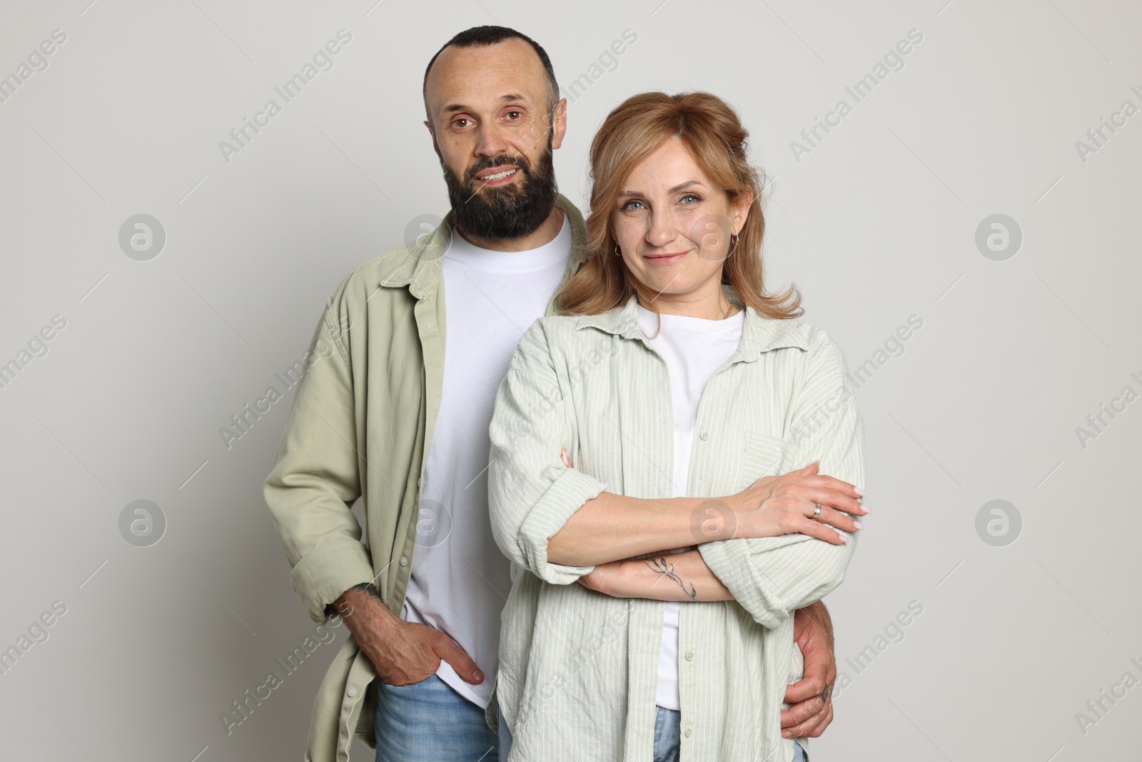 Portrait of lovely couple on light grey background Photo of Portrait of lovely couple on light grey background
