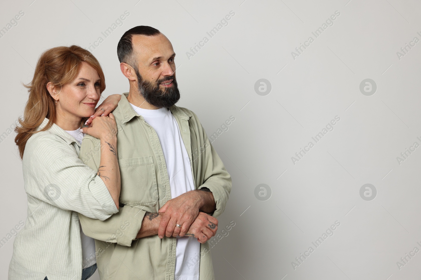 Portrait of lovely couple on light grey background, space for text Photo of Portrait of lovely couple on light grey background, space for text