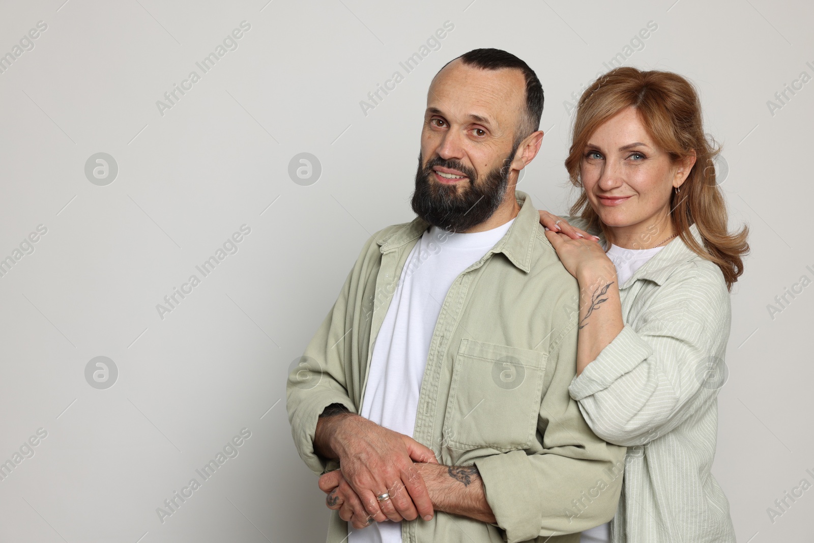 Portrait of lovely couple on light grey background, space for text Photo of Portrait of lovely couple on light grey background, space for text