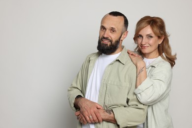 Photo of Portrait of lovely couple on light grey background, space for text