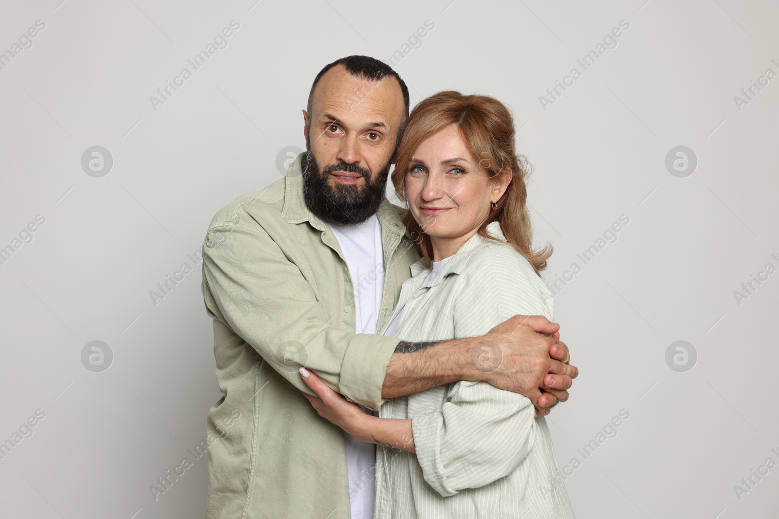 Portrait of lovely couple on light grey background Photo of Portrait of lovely couple on light grey background