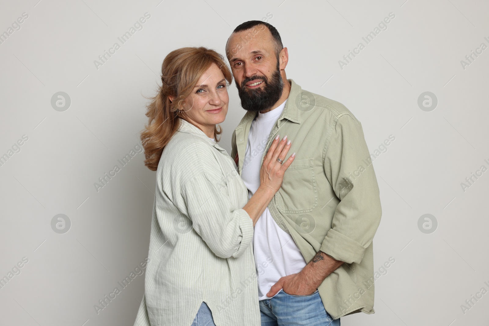 Portrait of lovely couple on light grey background Photo of Portrait of lovely couple on light grey background