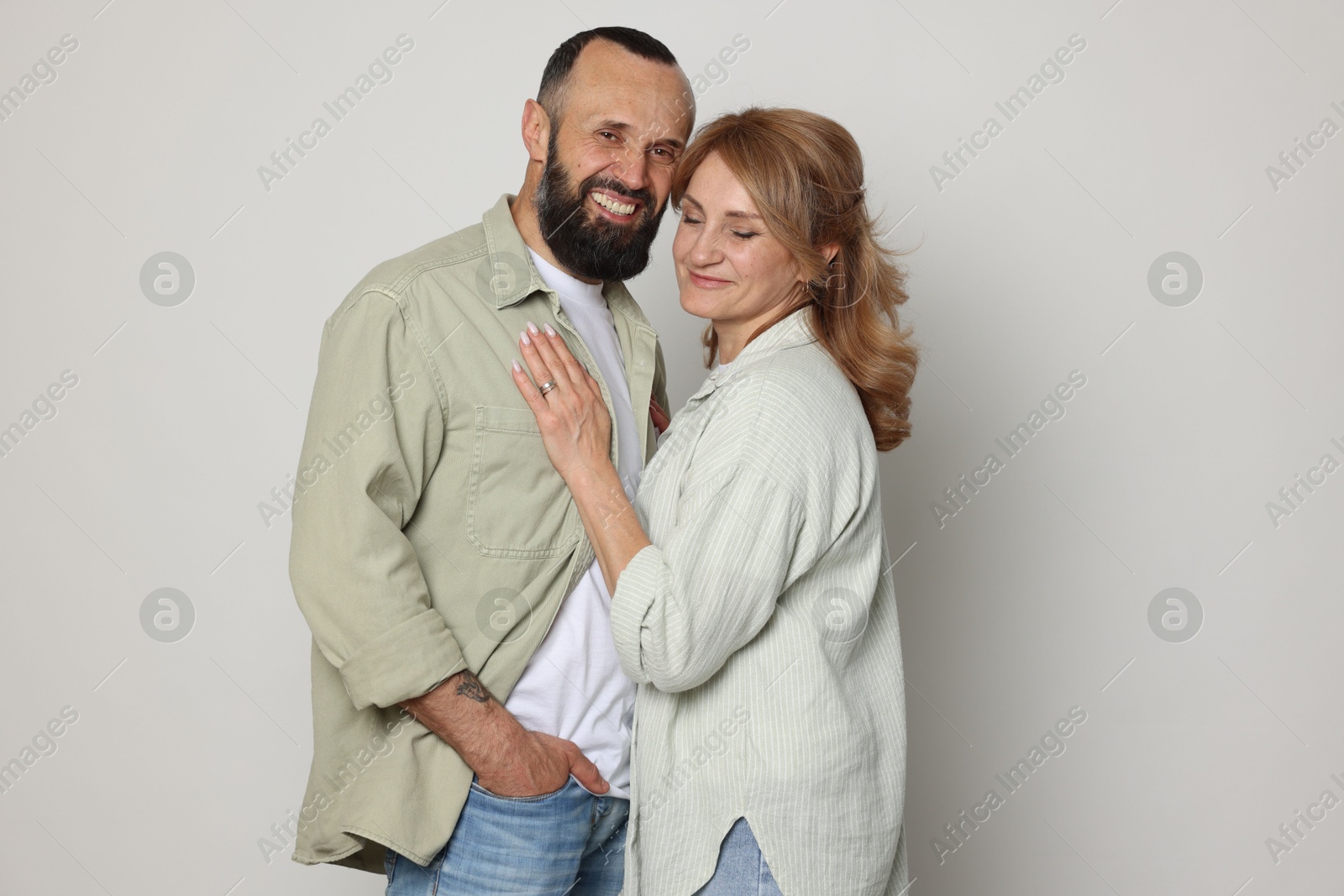 Portrait of lovely couple on light grey background Photo of Portrait of lovely couple on light grey background