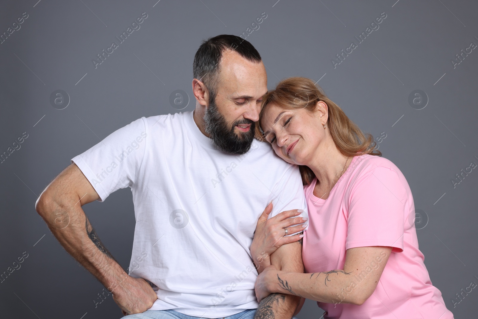 Portrait of lovely couple on grey background Photo of Portrait of lovely couple on grey background