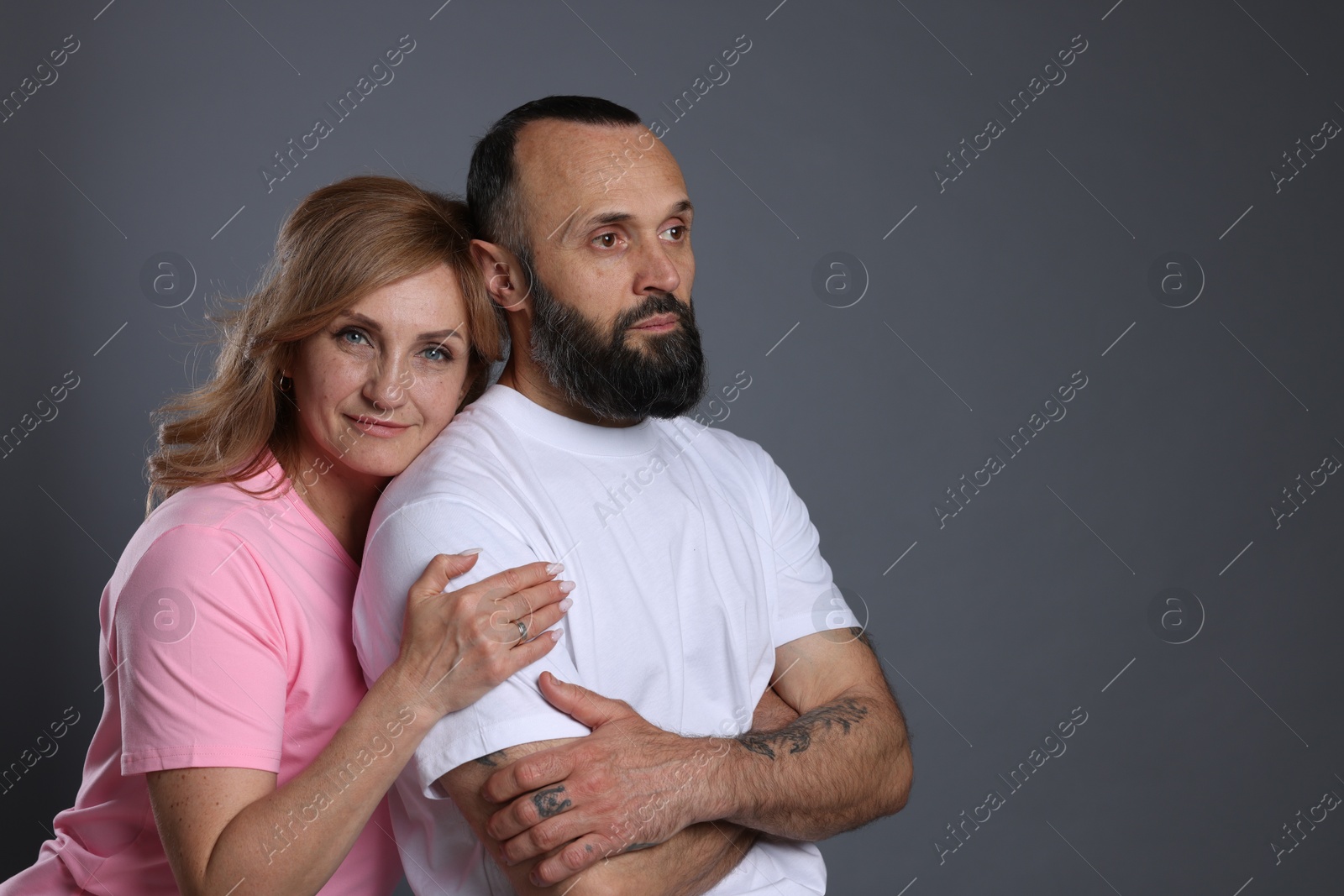 Portrait of lovely couple on grey background, space for text Photo of Portrait of lovely couple on grey background, space for text