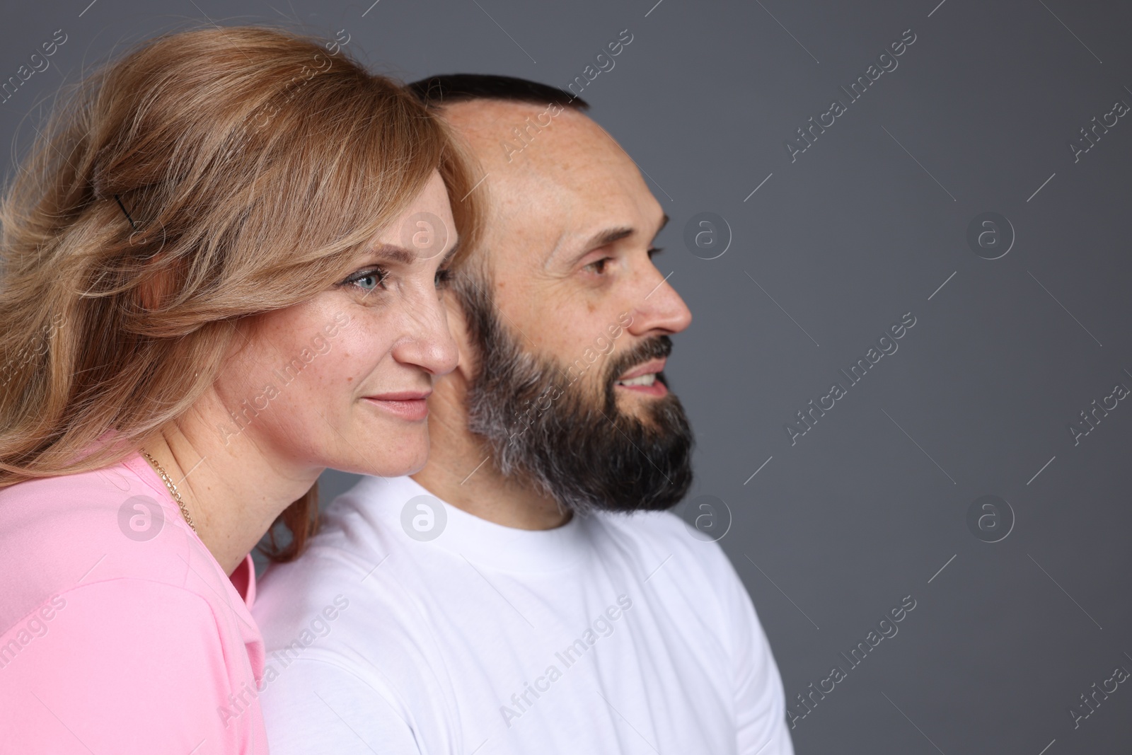 Portrait of lovely couple on grey background, space for text Photo of Portrait of lovely couple on grey background, space for text