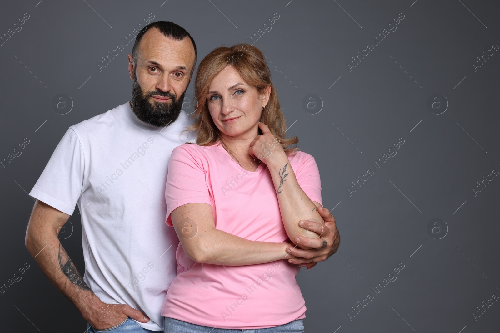 Portrait of lovely couple on grey background, space for text Photo of Portrait of lovely couple on grey background, space for text