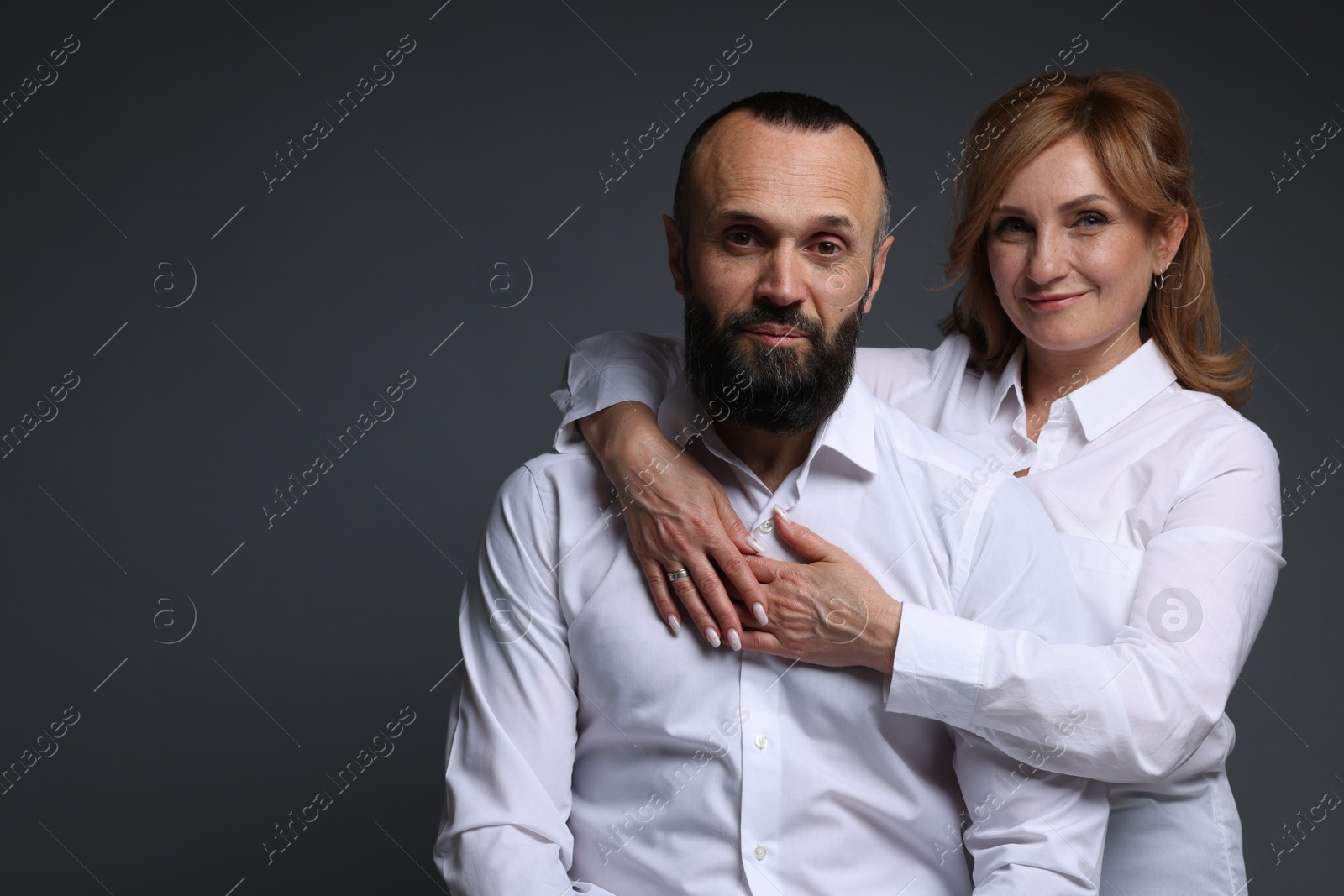 Portrait of lovely couple on grey background, space for text Photo of Portrait of lovely couple on grey background, space for text