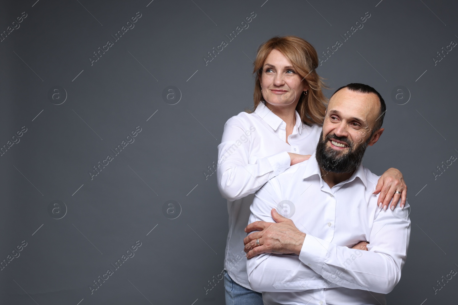 Portrait of lovely couple on grey background, space for text Photo of Portrait of lovely couple on grey background, space for text