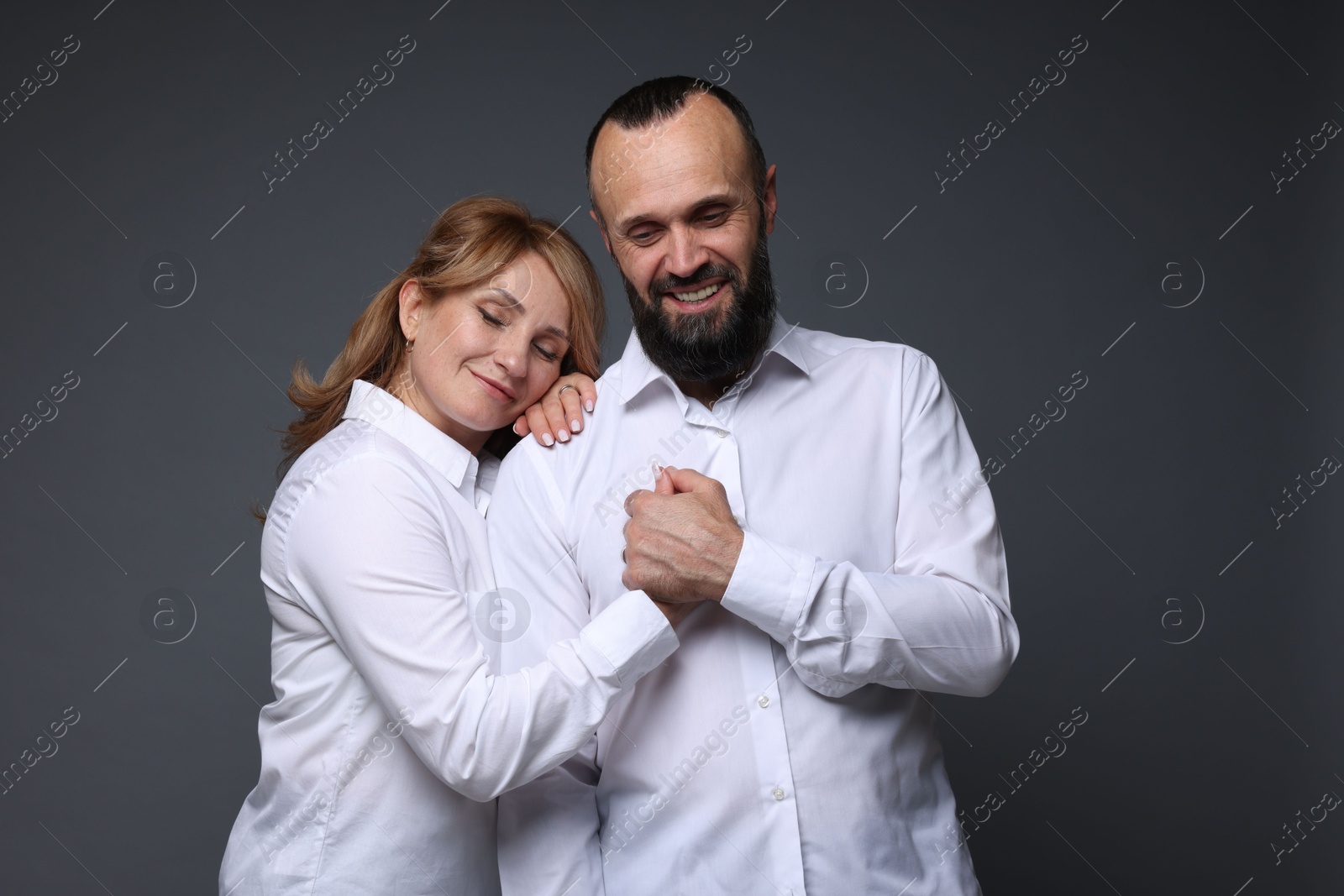 Portrait of lovely couple on grey background Photo of Portrait of lovely couple on grey background