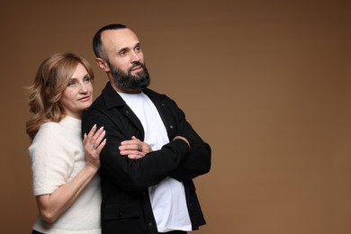 Photo of Portrait of lovely couple on brown background, space for text