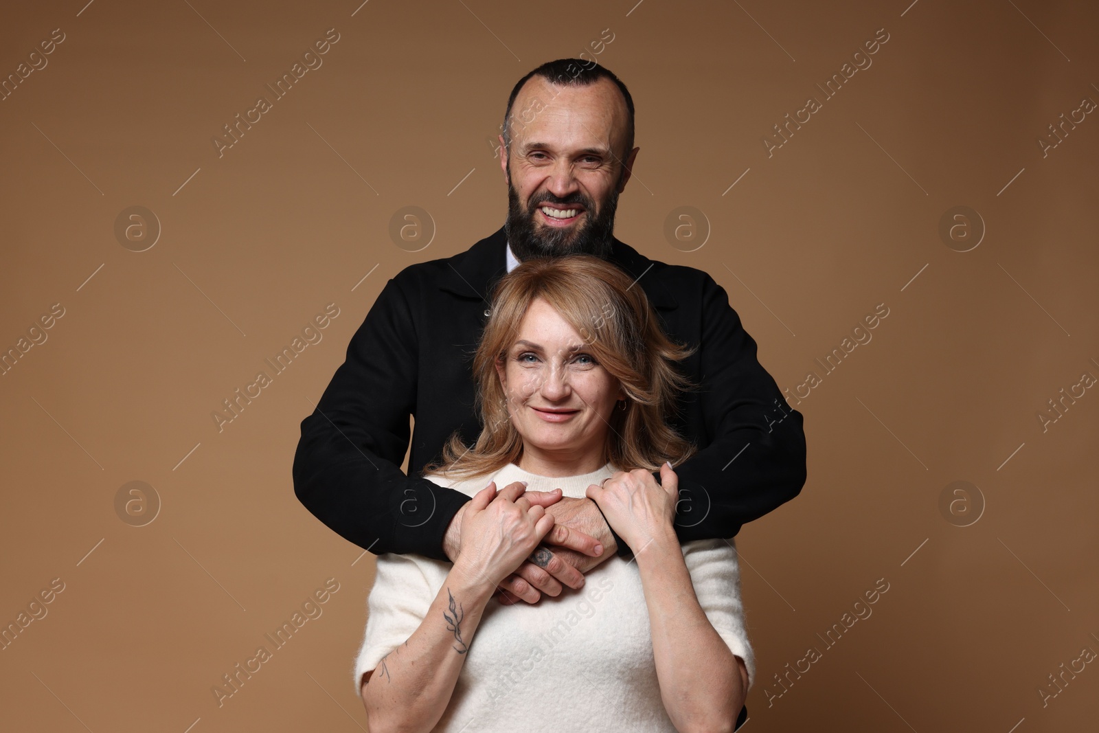 Portrait of lovely couple on brown background Photo of Portrait of lovely couple on brown background