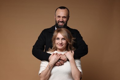Photo of Portrait of lovely couple on brown background