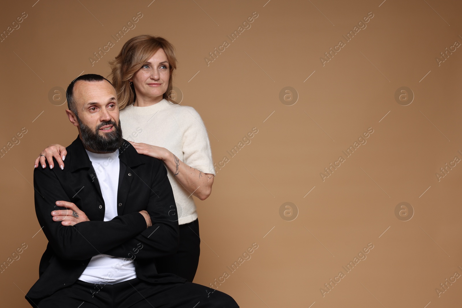 Portrait of lovely couple on brown background, space for text Photo of Portrait of lovely couple on brown background, space for text