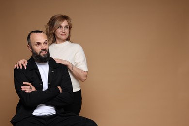 Photo of Portrait of lovely couple on brown background, space for text