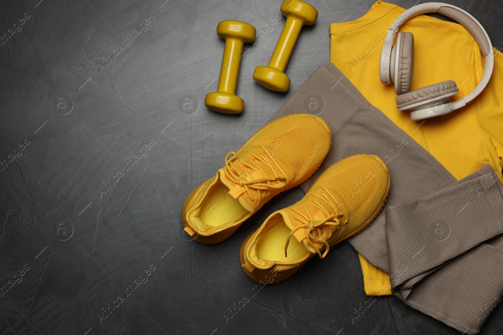 Sportswear, sneakers, dumbbells and headphones on grey background, flat lay. Space for text Photo of Sportswear, sneakers, dumbbells and headphones on grey background, flat lay. Space for text