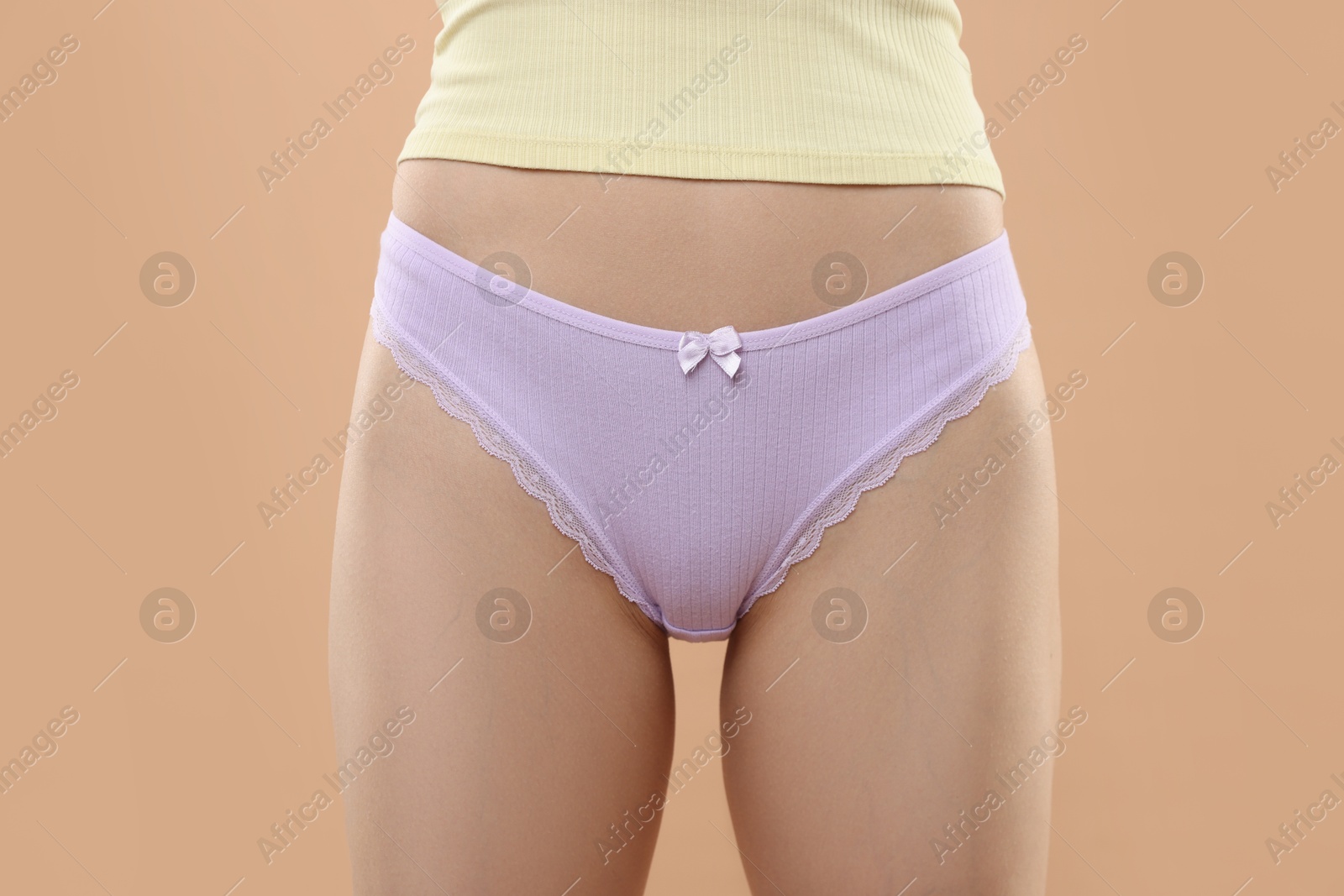 Woman wearing beautiful underwear on beige background, closeup Photo of Woman wearing beautiful underwear on beige background, closeup