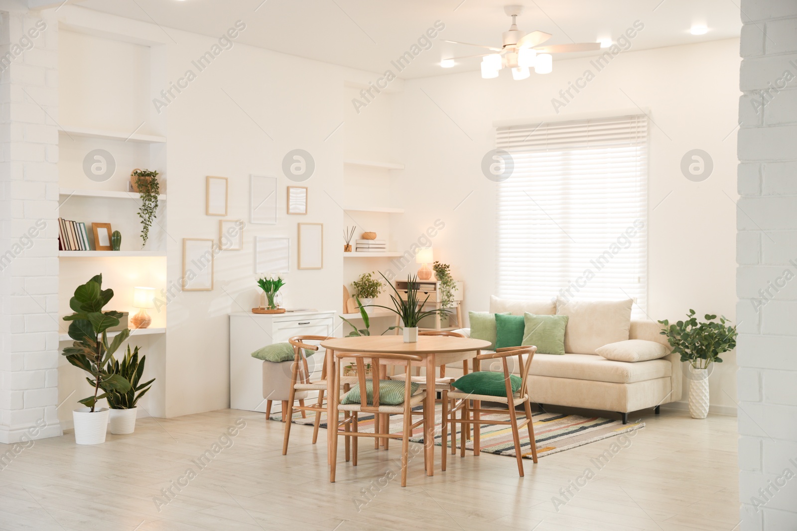 Stylish dining table with chairs and comfortable sofa in room. Interior design Photo of Stylish dining table with chairs and comfortable sofa in room. Interior design