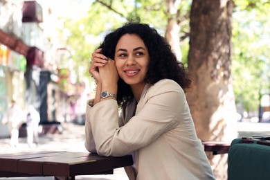 Photo of Portrait of smiling Latin American woman in outdoor cafe