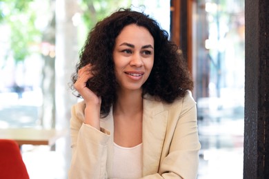 Photo of Portrait of smiling Latin American woman in cafe
