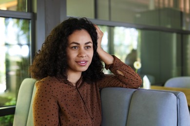 Photo of Portrait of smiling Latin American woman in cafe