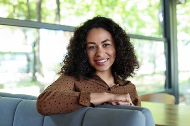 Photo of Portrait of smiling Latin American woman in cafe