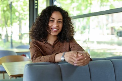 Photo of Portrait of smiling Latin American woman in cafe
