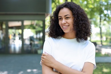Photo of Portrait of smiling Latin American woman outdoors. Space for text
