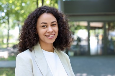 Photo of Portrait of smiling Latin American woman outdoors. Space for text
