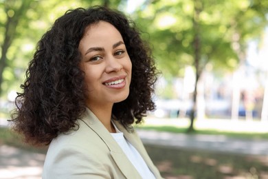 Photo of Portrait of smiling Latin American woman outdoors. Space for text