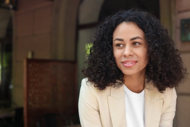 Photo of Portrait of smiling Latin American woman outdoors. Space for text