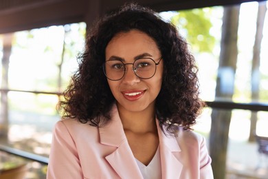 Photo of Portrait of smiling Latin American woman in cafe