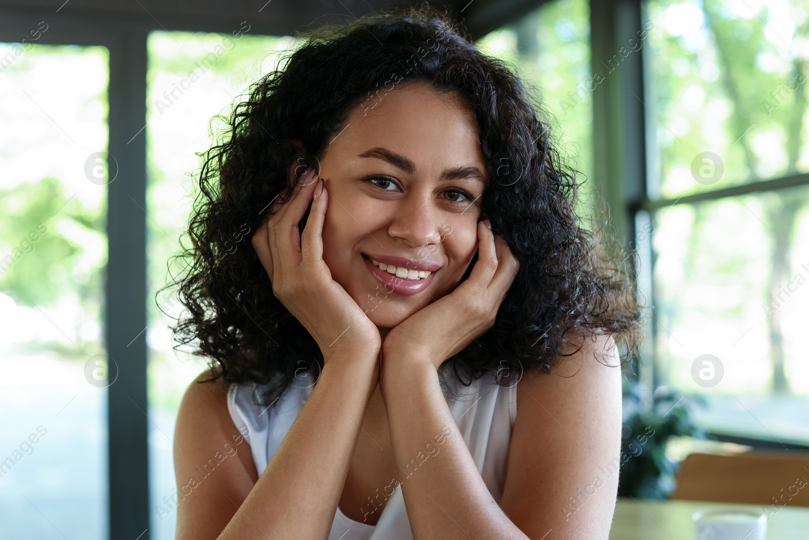 Portrait of smiling Latin American woman in cafe Photo of Portrait of smiling Latin American woman in cafe