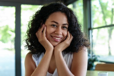 Photo of Portrait of smiling Latin American woman in cafe