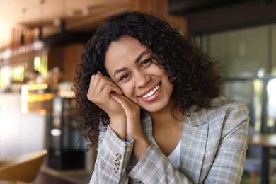 Photo of Portrait of smiling Latin American woman in cafe