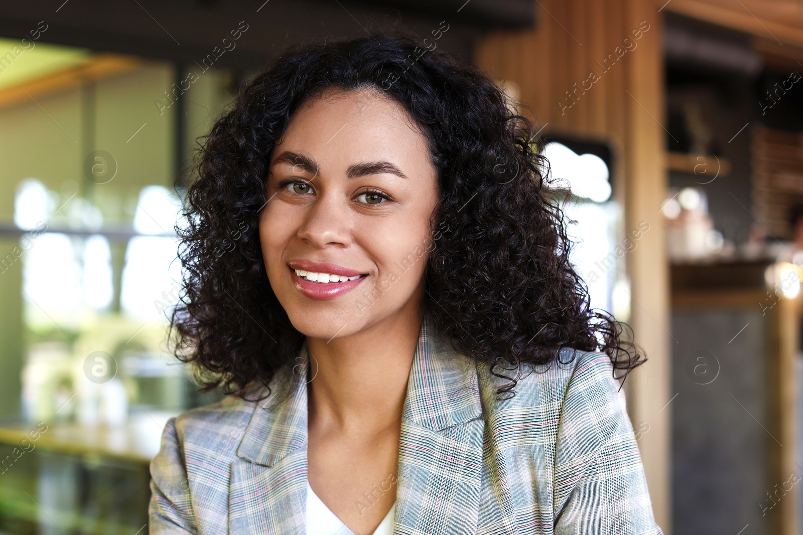 Portrait of smiling Latin American woman in cafe Photo of Portrait of smiling Latin American woman in cafe