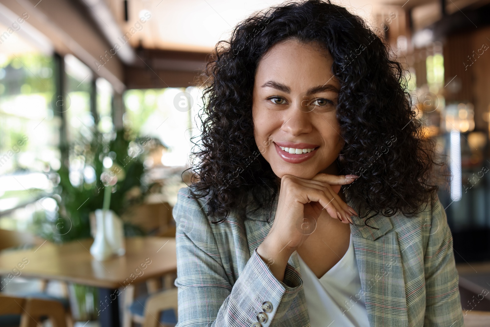 Portrait of smiling Latin American woman in cafe. Space for text Photo of Portrait of smiling Latin American woman in cafe. Space for text