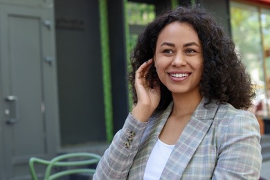 Photo of Portrait of smiling Latin American woman outdoors. Space for text