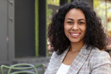 Photo of Portrait of smiling Latin American woman outdoors. Space for text