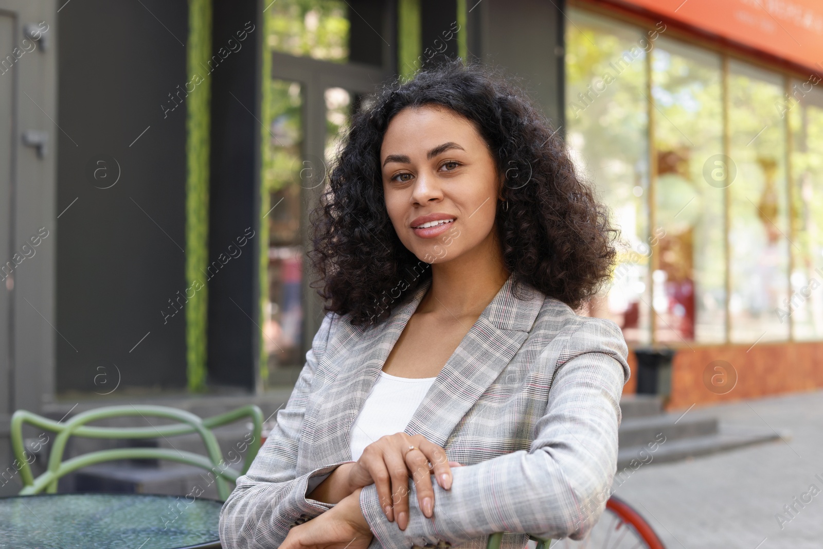 Portrait of smiling Latin American woman in outdoor cafe Photo of Portrait of smiling Latin American woman in outdoor cafe