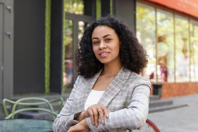 Photo of Portrait of smiling Latin American woman in outdoor cafe