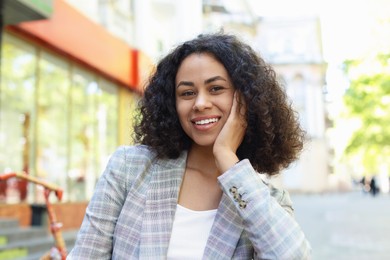 Photo of Portrait of smiling Latin American woman outdoors