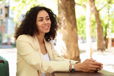 Photo of Portrait of smiling Latin American woman in outdoor cafe
