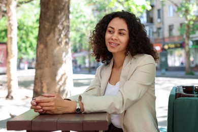 Photo of Portrait of smiling Latin American woman in outdoor cafe