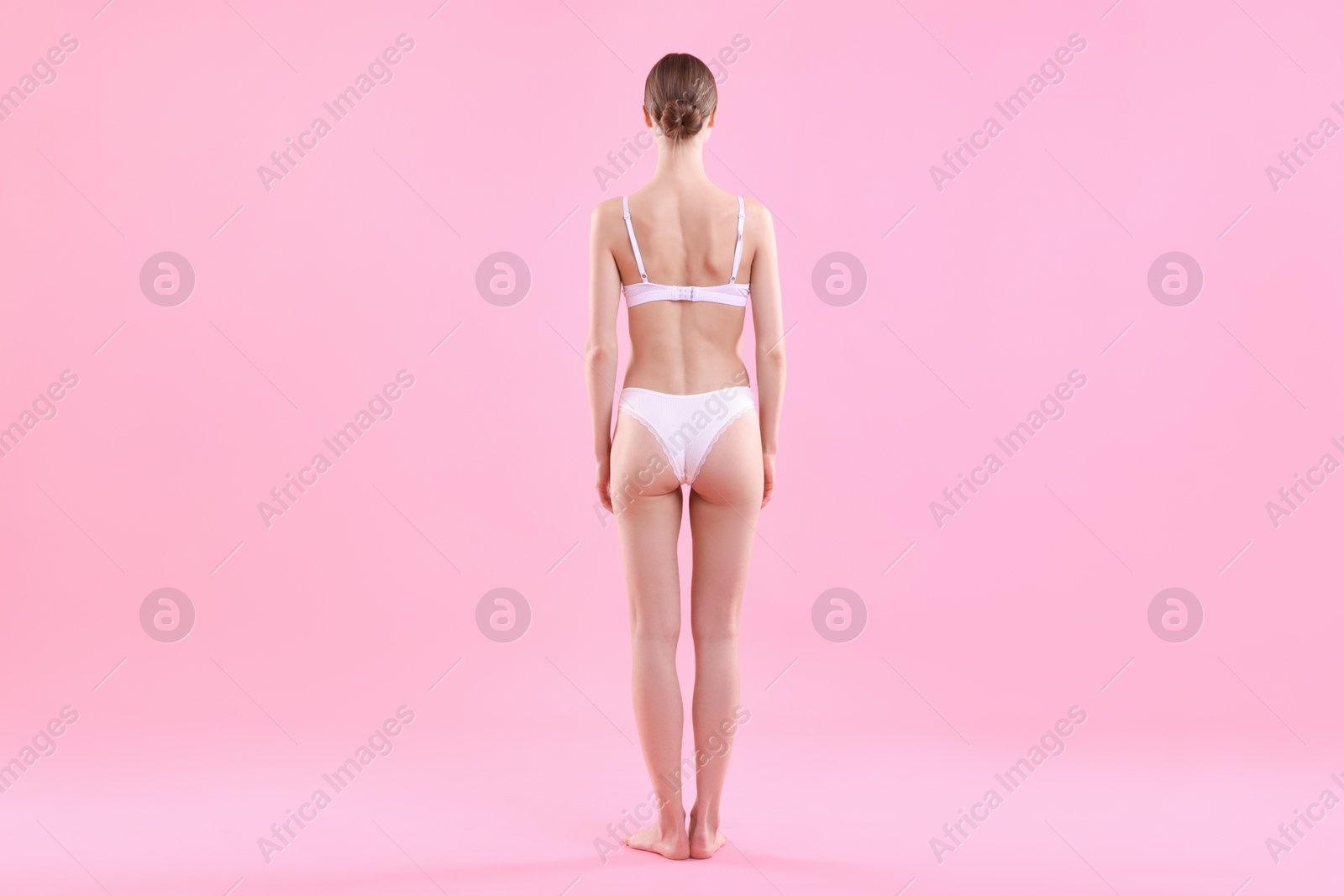 Woman wearing beautiful underwear on pink background, back view Photo of Woman wearing beautiful underwear on pink background, back view