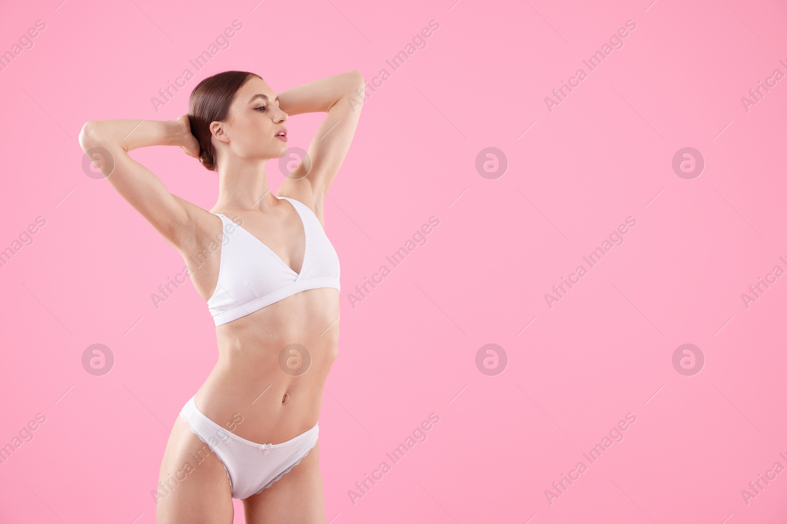 Woman wearing beautiful underwear on pink background, space for text Photo of Woman wearing beautiful underwear on pink background, space for text