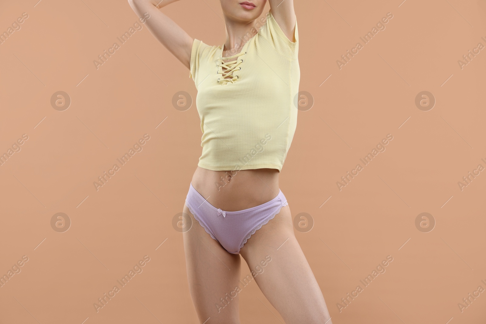 Woman wearing beautiful underwear on beige background, closeup Photo of Woman wearing beautiful underwear on beige background, closeup