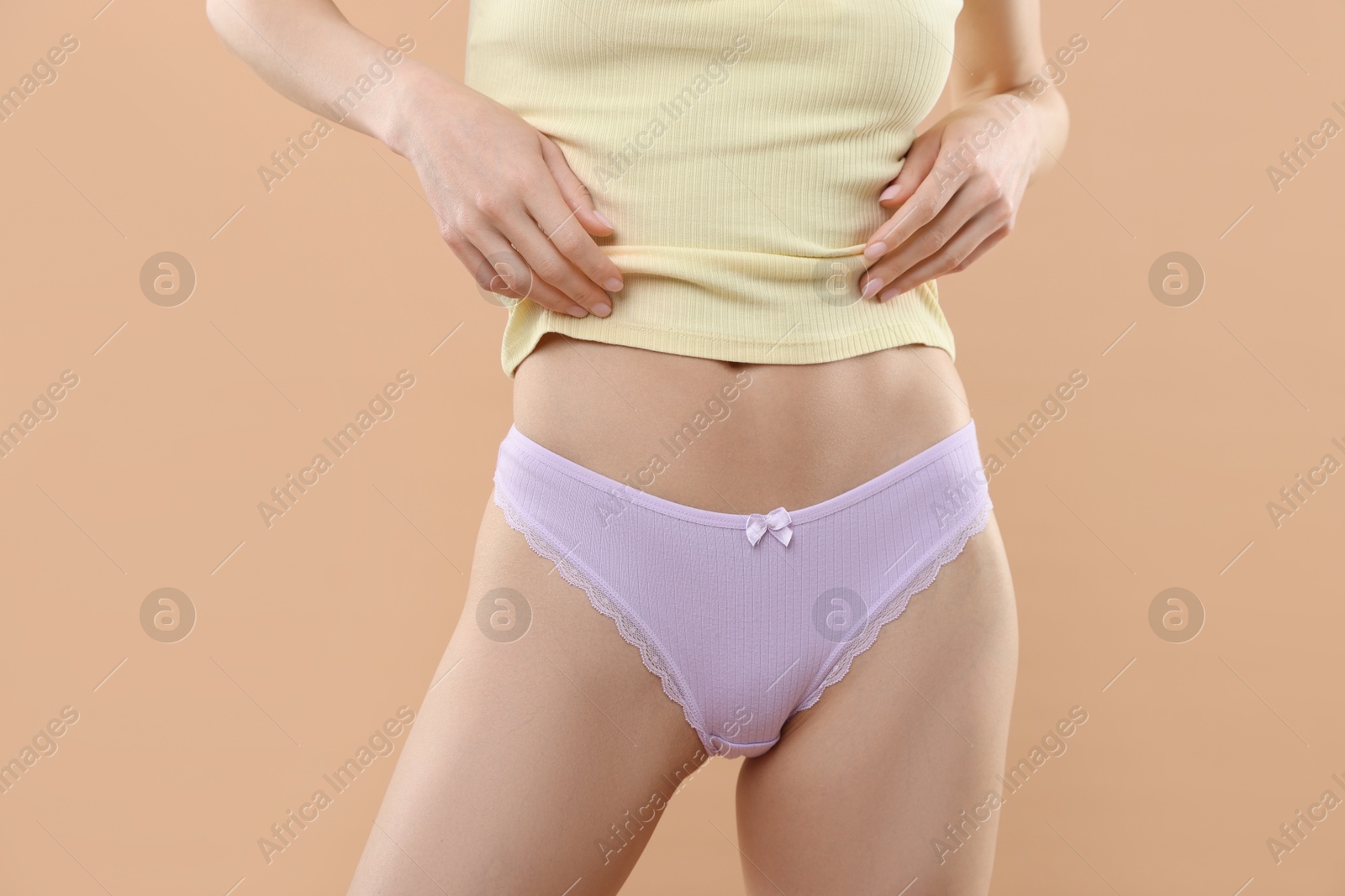 Woman wearing beautiful underwear on beige background, closeup Photo of Woman wearing beautiful underwear on beige background, closeup