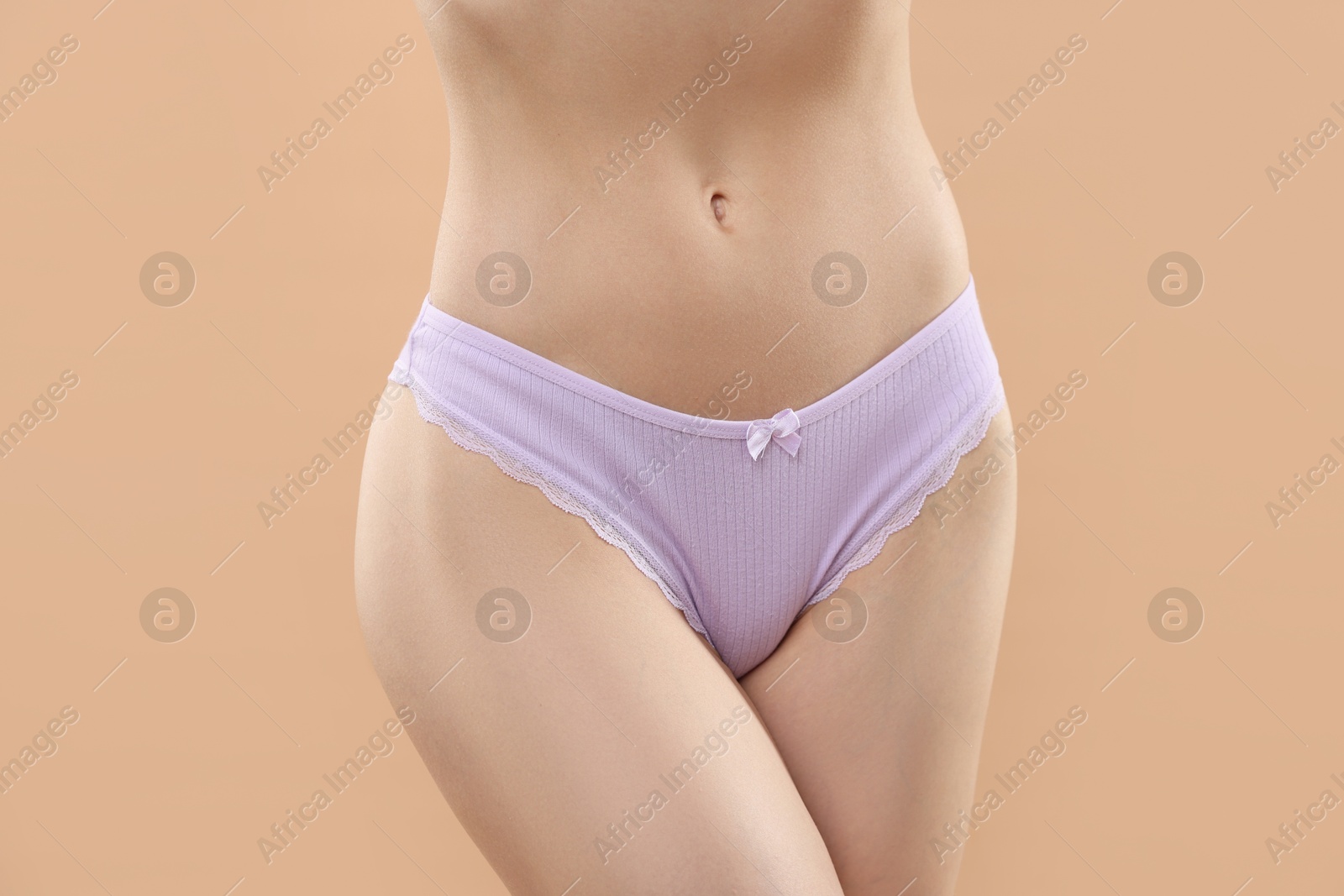 Woman wearing beautiful underwear on beige background, closeup Photo of Woman wearing beautiful underwear on beige background, closeup